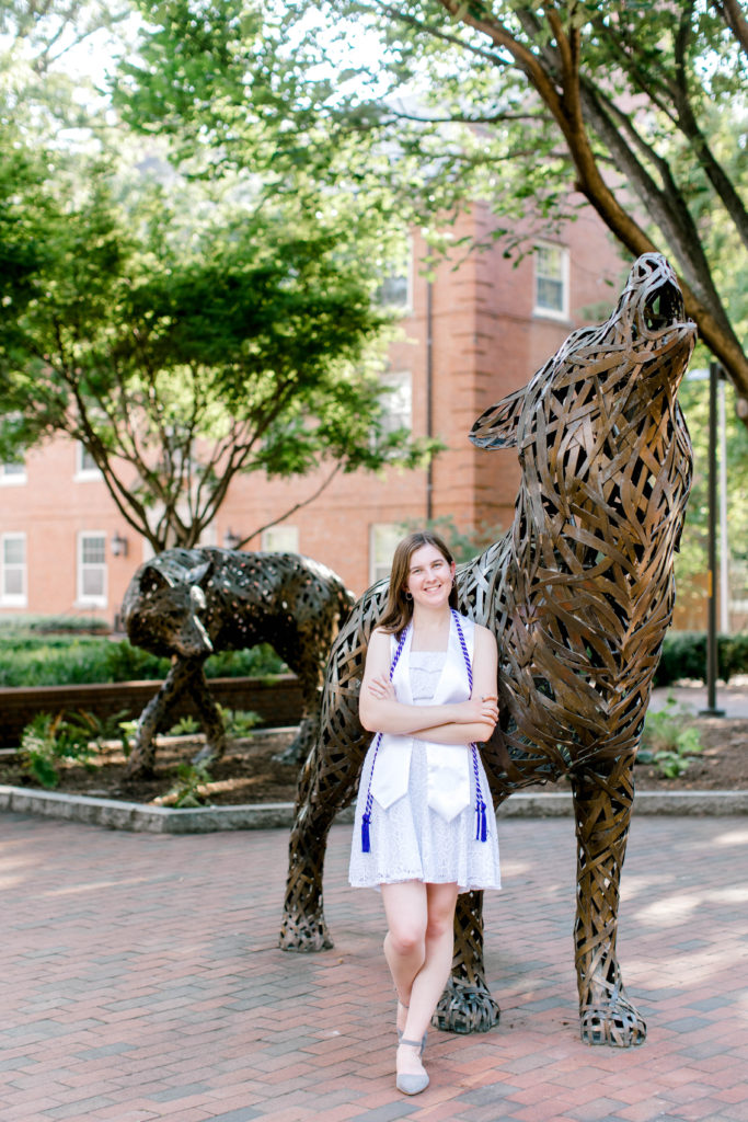 Larissa solo graduation photo outside in front of statue