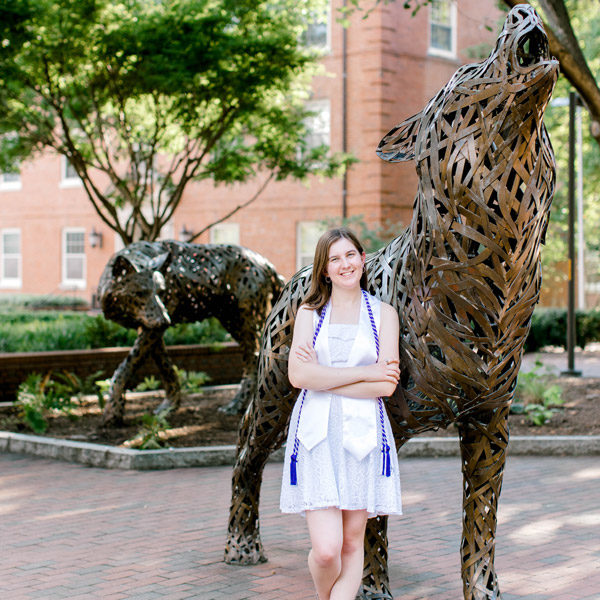Larissa graduation photo outside in front of statue