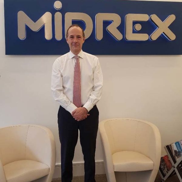 Midrex Employee in front of logo